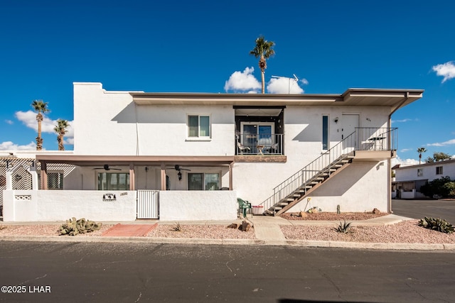 1824 Montana Vis Unit D, Lake Havasu City, AZ 86403 - view of front facade featuring a fenced front yard, ceiling fan, stairs, stucco siding, and a gate