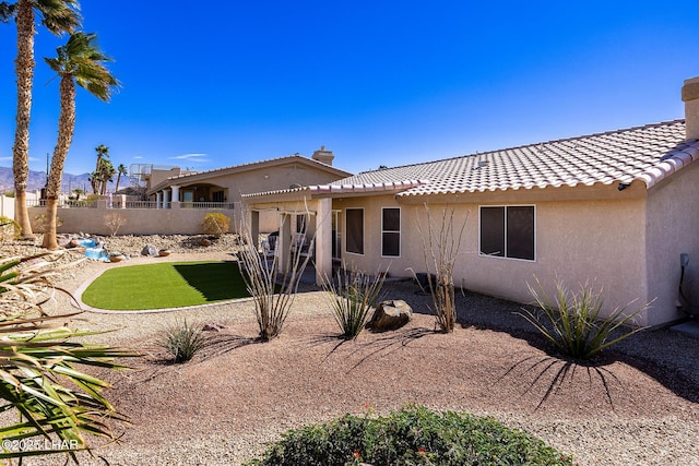 back of property featuring a chimney, stucco siding, a patio area, fence, and a tiled roof