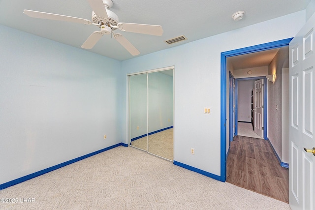 unfurnished bedroom with ceiling fan, visible vents, baseboards, a closet, and carpet