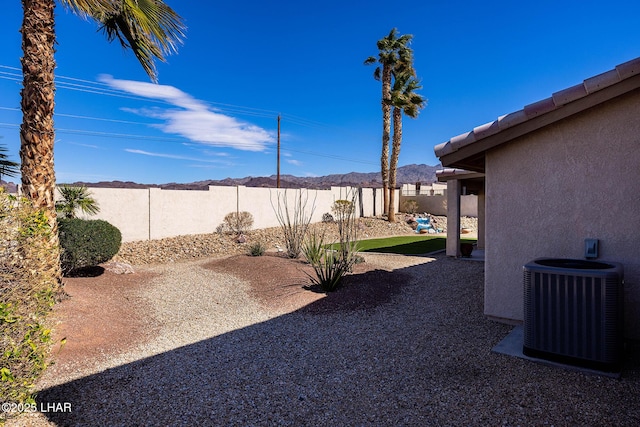 view of yard featuring a patio area, a fenced backyard, a mountain view, and cooling unit