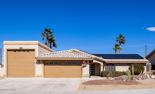 single story home featuring a garage, roof mounted solar panels, concrete driveway, and stucco siding