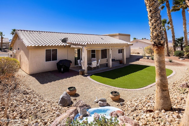 back of house featuring fence, a patio area, a tile roof, and stucco siding