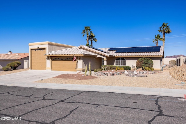 view of front of property featuring a tile roof, driveway, and stucco siding