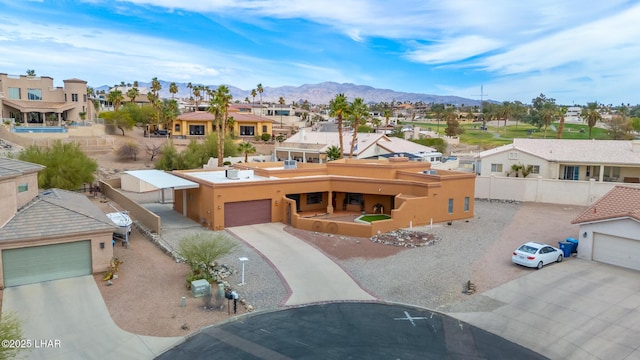 view of front of property with a garage, a residential view, a mountain view, and fence