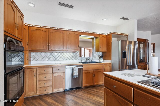 kitchen with light countertops, appliances with stainless steel finishes, a sink, and visible vents