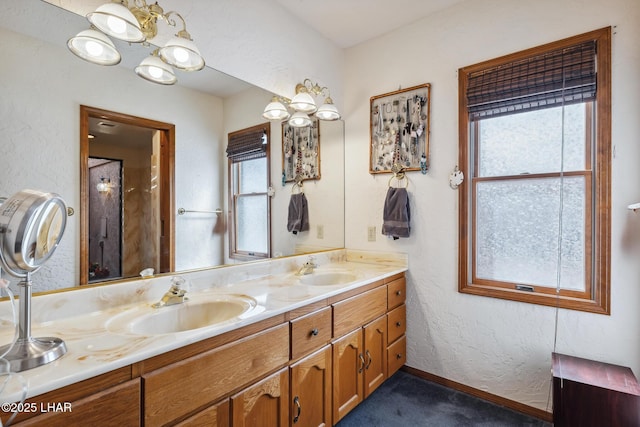 bathroom with double vanity, a sink, and a textured wall