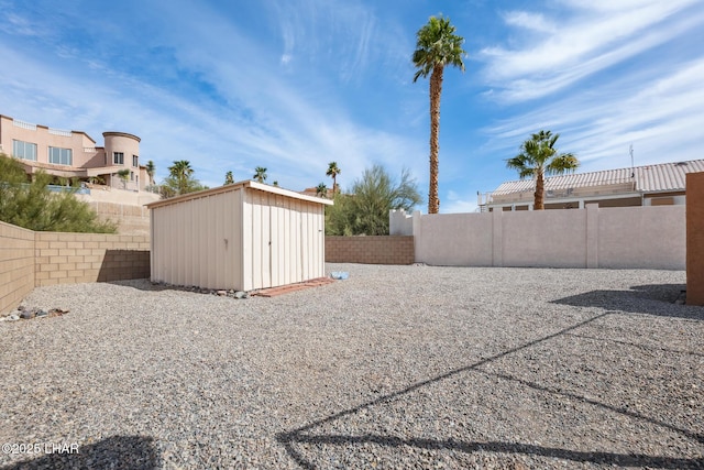 view of yard with an outbuilding, a shed, and a fenced backyard