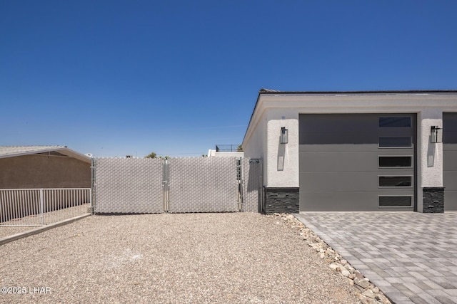 2185 Palo Verde Blvd S, Lake Havasu City, AZ 86403 - view of side of home with stucco siding, driveway, stone siding, and a garage
