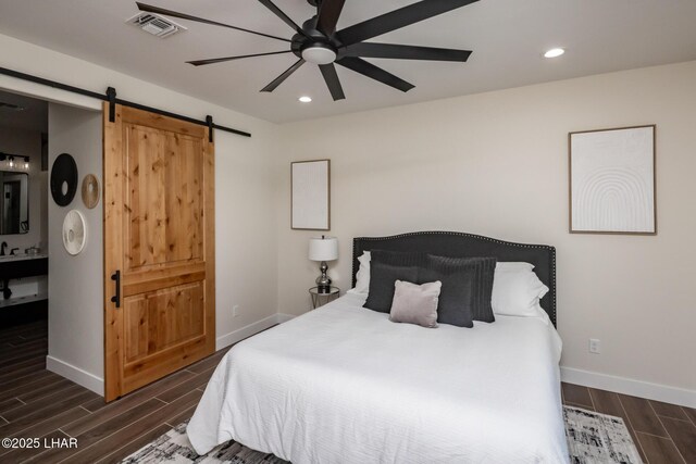 2185 Palo Verde Blvd S, Lake Havasu City, AZ 86403 - bedroom featuring a barn door, wood tiled floors, recessed lighting, a ceiling fan, and ensuite bathroom