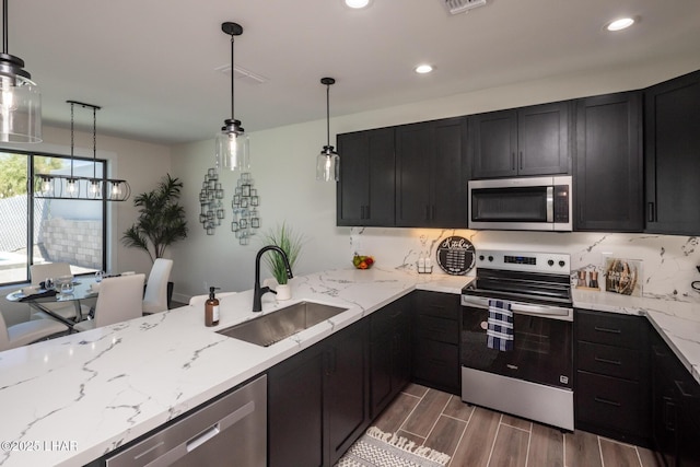 2185 Palo Verde Blvd S, Lake Havasu City, AZ 86403 - kitchen with appliances with stainless steel finishes, dark cabinetry, light stone countertops, dark wood-style flooring, and decorative light fixtures
