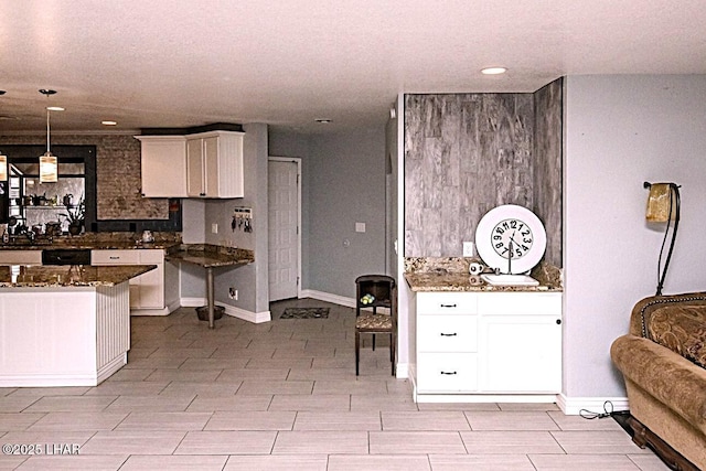 kitchen with dark stone countertops, hanging light fixtures, and white cabinets