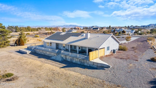 view of front of home with roof mounted solar panels, a mountain view, and a tiled roof