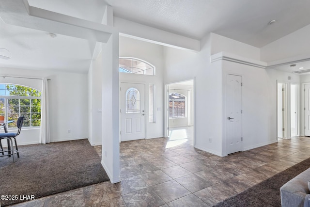 entryway featuring carpet floors, a high ceiling, and baseboards