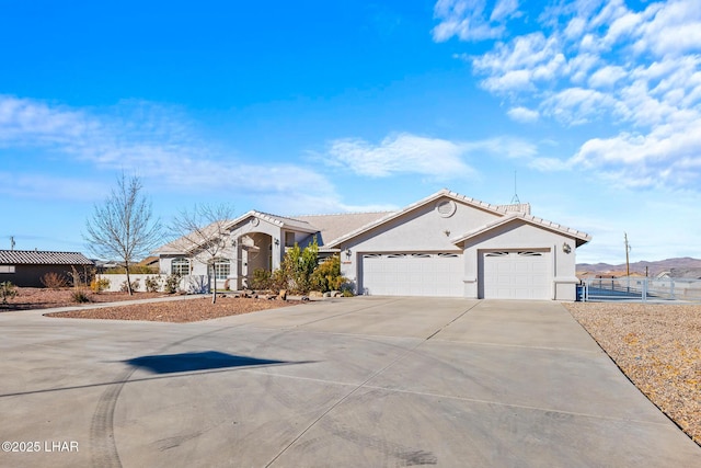 mediterranean / spanish-style house with driveway, fence, an attached garage, and stucco siding