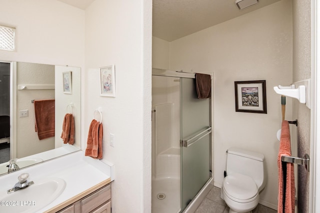 bathroom with vanity, tile patterned floors, a shower with door, and toilet