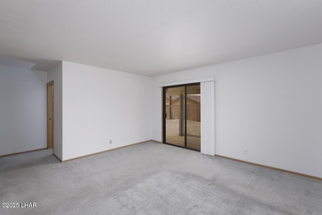 carpeted spare room featuring baseboards
