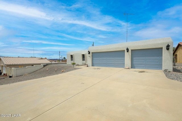 view of front facade featuring a garage, stucco siding, and concrete driveway