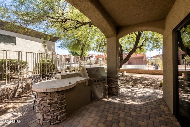 view of patio / terrace with a fenced backyard, a grill, and exterior kitchen