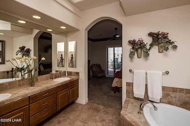 bathroom with a ceiling fan, double vanity, a sink, tile patterned flooring, and a bath