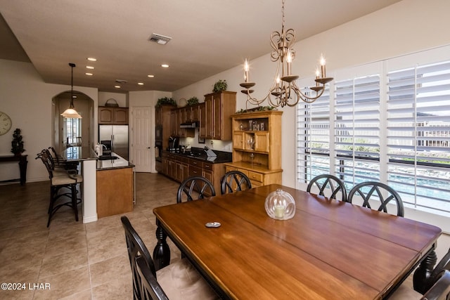 dining area with light tile patterned floors, visible vents, recessed lighting, arched walkways, and a chandelier