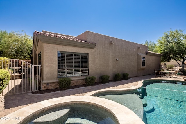 view of pool with a fenced in pool, a patio, an in ground hot tub, and fence