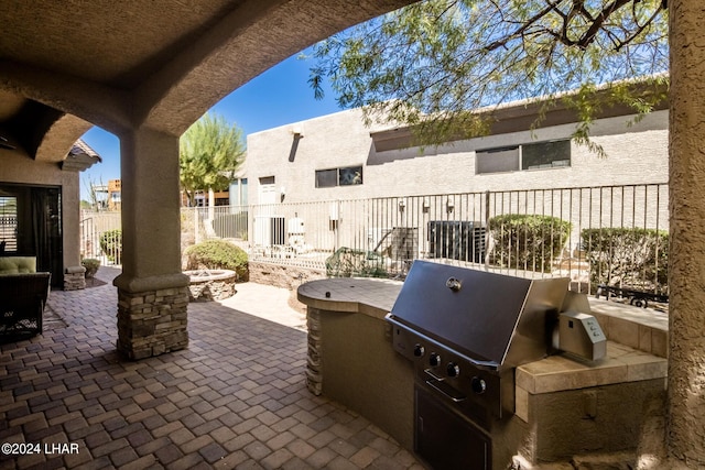 view of patio / terrace with exterior kitchen and fence