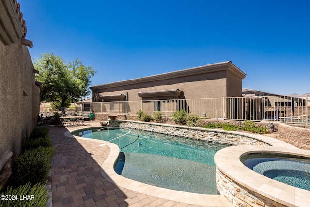 view of pool with a fenced in pool, an in ground hot tub, a patio, and fence