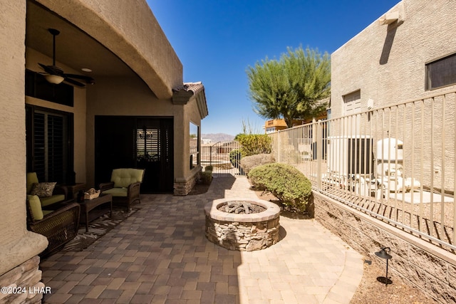 view of patio / terrace with a gate, a fire pit, a ceiling fan, and fence