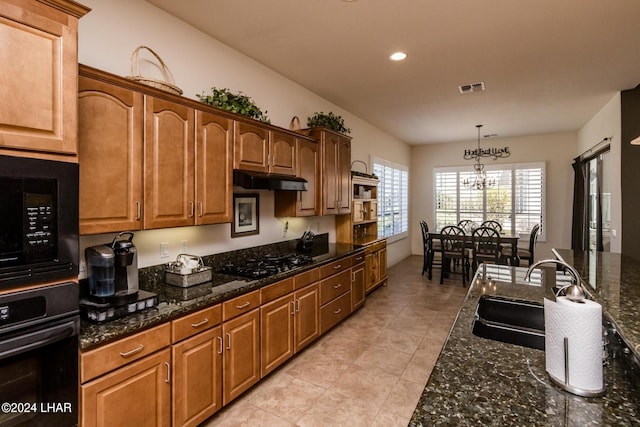 kitchen with visible vents, under cabinet range hood, pendant lighting, black appliances, and a sink