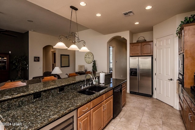 kitchen with arched walkways, recessed lighting, stainless steel appliances, and a sink