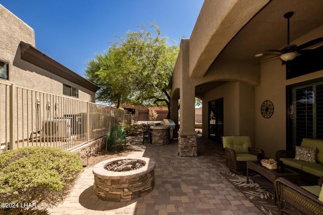 view of patio / terrace featuring area for grilling, a fenced backyard, ceiling fan, an outdoor living space with a fire pit, and a grill