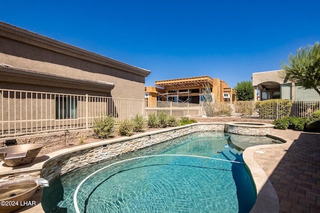 view of pool with a pool with connected hot tub and fence