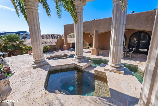 view of swimming pool with a patio, french doors, and an in ground hot tub