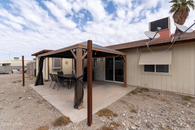 rear view of property featuring a gazebo, fence, and a patio