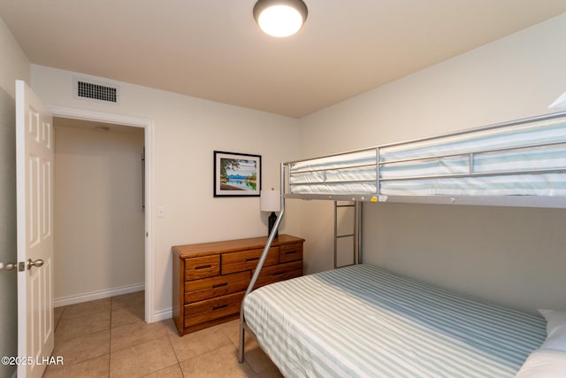 bedroom featuring baseboards, visible vents, and light tile patterned floors