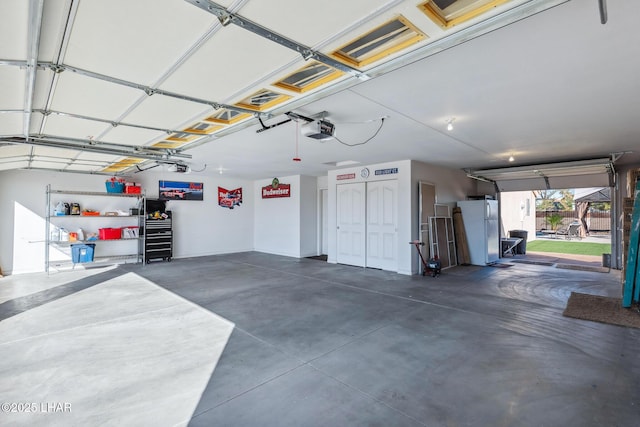 garage with a garage door opener and freestanding refrigerator