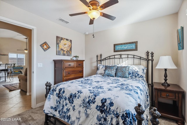 bedroom featuring a ceiling fan, visible vents, carpet floors, baseboards, and arched walkways