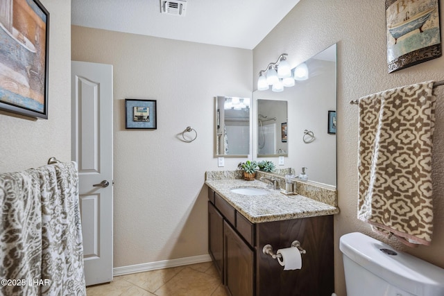 bathroom featuring vanity, visible vents, baseboards, tile patterned flooring, and toilet