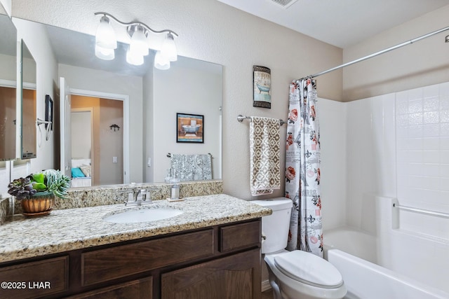 bathroom featuring vanity, toilet, a textured wall, and shower / bath combo with shower curtain