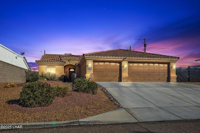 view of front of home featuring stucco siding, concrete driveway, an attached garage, and a tiled roof