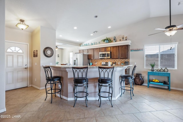 kitchen with a kitchen bar, light countertops, a healthy amount of sunlight, and stainless steel appliances