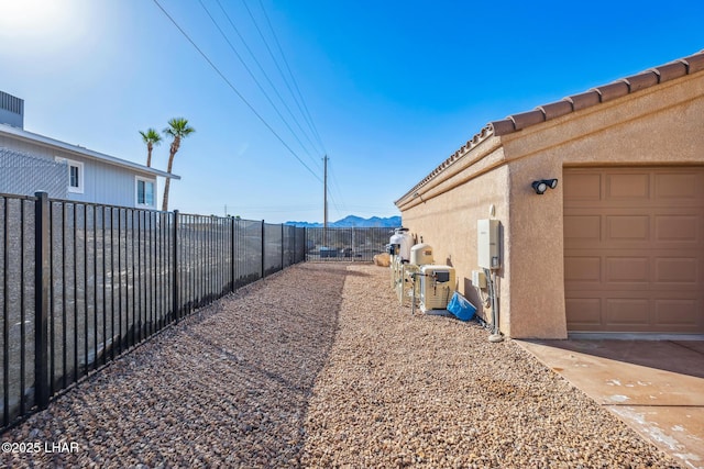 view of yard featuring a mountain view, a garage, and fence