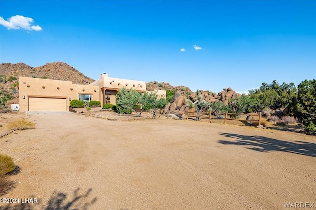 southwest-style home with a garage and a mountain view