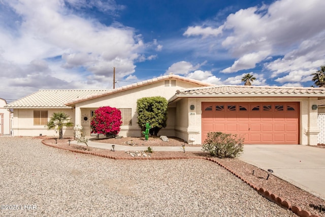 view of front of property with a garage, driveway, a tile roof, and stucco siding