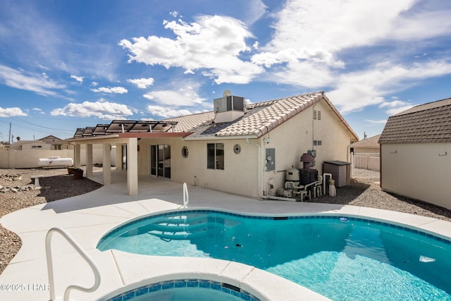 rear view of property featuring a fenced in pool, a tile roof, an in ground hot tub, a patio area, and stucco siding