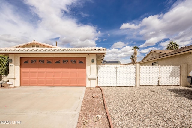 view of front of property with driveway, an attached garage, a tiled roof, and stucco siding