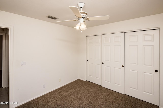 unfurnished bedroom featuring ceiling fan, visible vents, baseboards, a closet, and dark carpet