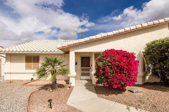 view of front of home featuring a tile roof and stucco siding