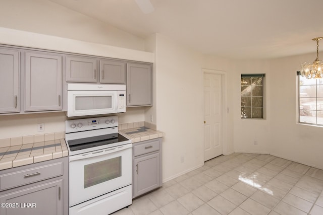 kitchen featuring white appliances, tile counters, and gray cabinets