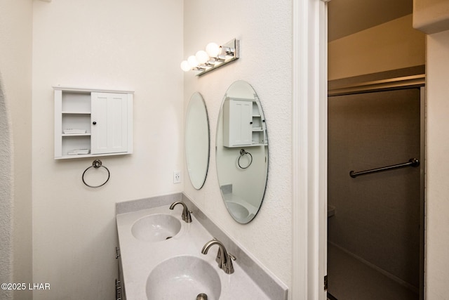 full bathroom with double vanity, an enclosed shower, and a sink